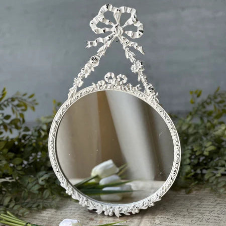 Decorative mirror with floral design on a textured surface with flowers